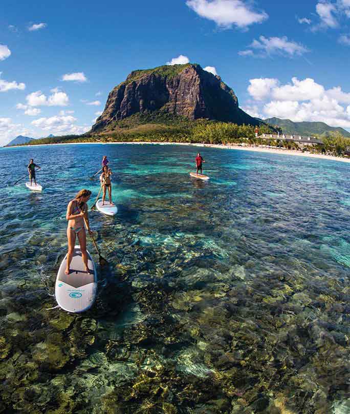 Paddle boarders gliding over Mauritius lagoon at Le Morne
